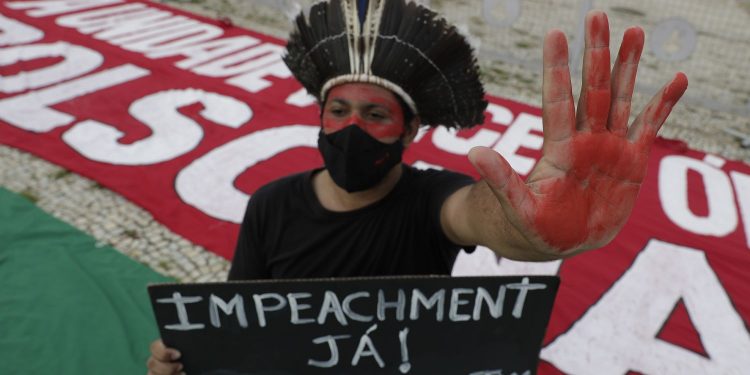 Manifestante protesta contra o presidente Jair Bolsonaro na frente do Planalto, no último sábado.ERALDO PERES / AP