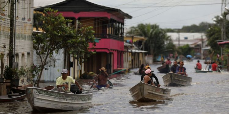 People pass on their boats through a street flooded by the rising Solimoes river, one of the two main branches of the Amazon River, in Anama, Amazonas state, Brazil May 13, 2021. Picture taken May 13, 2021. REUTERS/Bruno Kelly