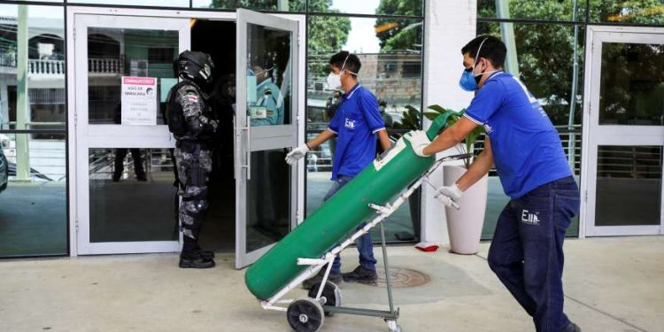 Trabalhadores chegam a hospital em Manaus, no Amazonas, com cilindro de oxigênio em meio a colapso do sistema de saúde no começo de 2021
- Foto: Bruno Kelly/Reuters (14.jan.2021)