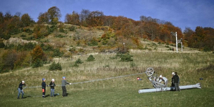 Trabalhadores desmontam o local de um teleférico em Saint Firmin, no leste da França, nos Alpes franceses, em outubro de 2022. Foto: Olivier Chassignole/AFP.