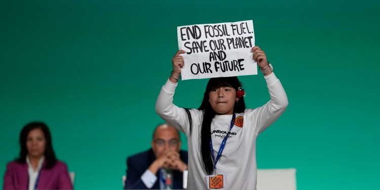 A manifestante Licypriya Kangujam segurando uma placa que diz "Acabem com os combustíveis fósseis. Salvem nosso planeta e o nosso futuro" - foto: AP