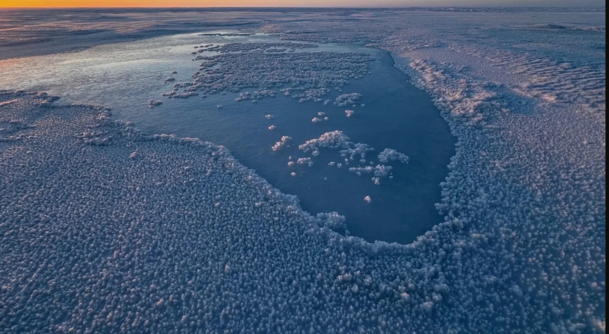 Água do mar recém-bombeada congela, formando camadas de novo gelo em Cambridge Bay.