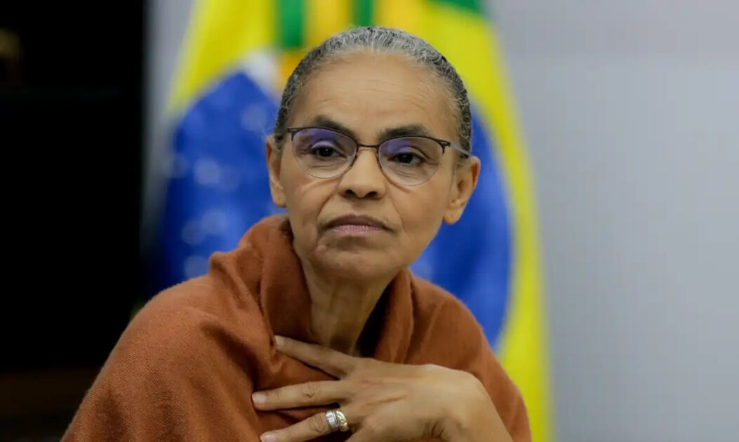 Imagem da ministra Marina Silva em frente à bandeira do Brasil. Segundo Marina Silva, Lula deve vetar parcialmente o texto do PL da Devastação.
