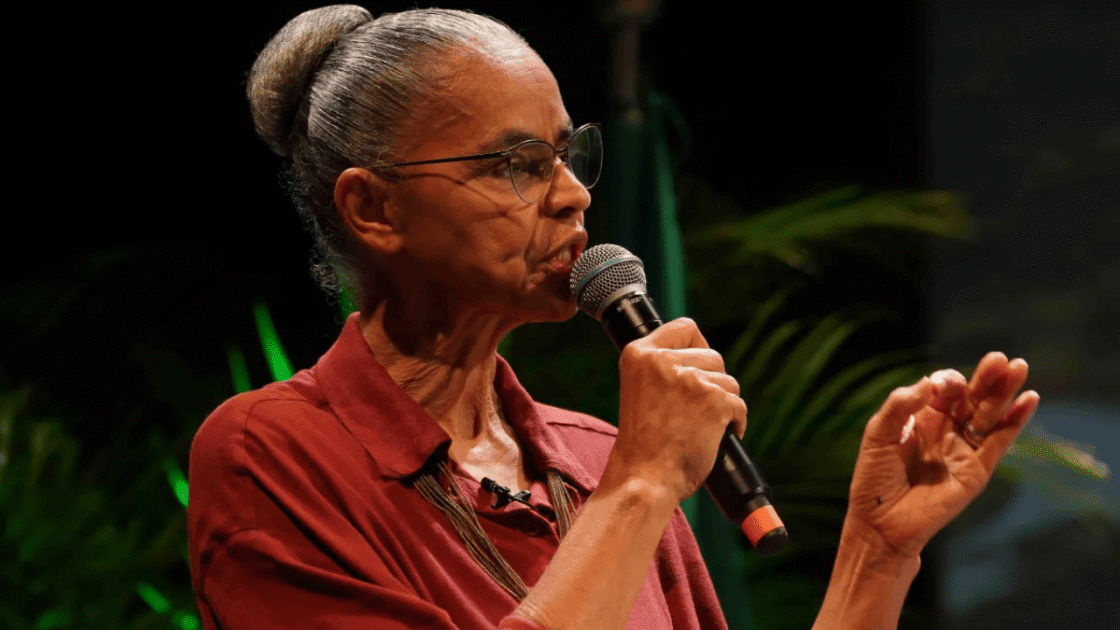 Ministra do Meio Ambiente e Mudança do Clima, Marina Silva, com cabelo preso em coque, vestindo camisa vermelha.

