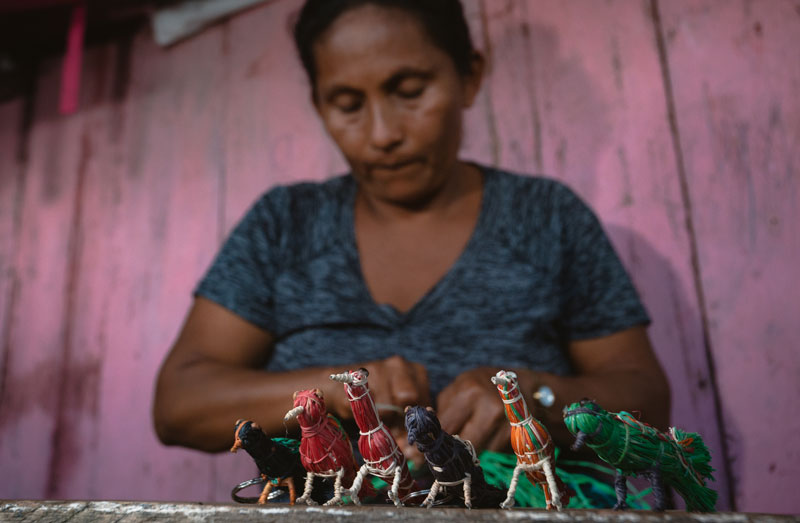 Indígena Maijuna-Kichwa produzindo peças de artesanato.