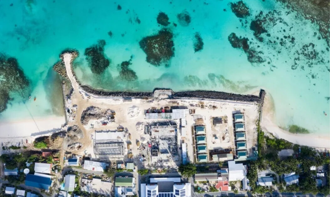 Imagem aérea do centro de Funafuti. Um projeto de recuperação de terras no centro de Funafuti, capital de Tuvalu, visa ampliar a área disponível para novas construções governamentais. Com areia dragada do oceano, já foram criados 3 km² de território em Tuvalu.