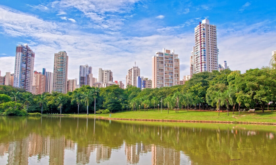 Imagem de cidade com áreas verdes e lago, simbolizando desafios de planejamento urbano no contexto do PL da Devastação. Foto: Canva.