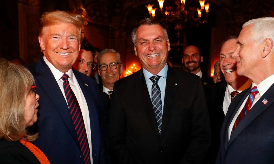 Trump e Bolsonaro sorrindo lado a lado em jantar promovido pelo então presidente dos EUA em 2020.