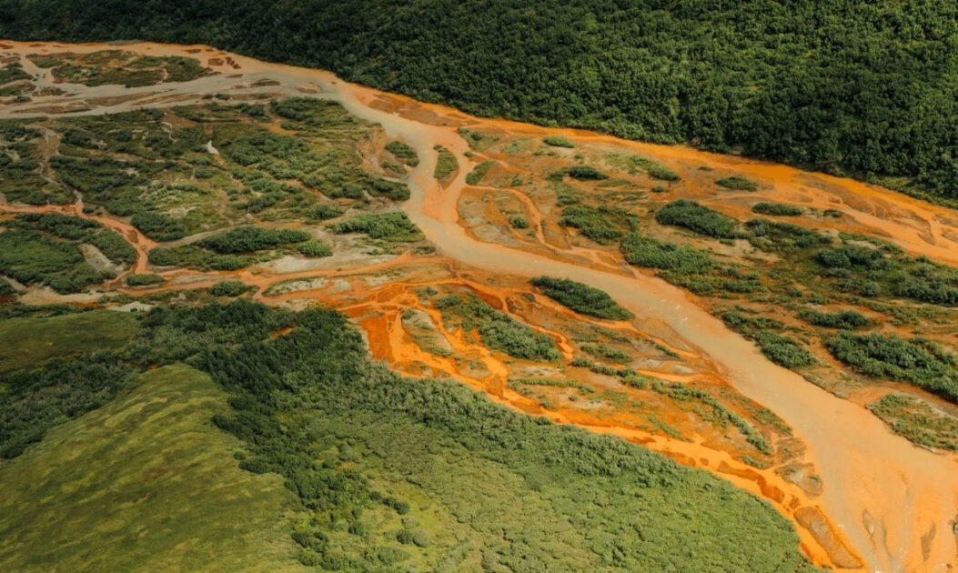 Rio do Alasca tingido de laranja pelos impactos das mudanças climáticas no Ártico e pela liberação de metais tóxicos após o degelo do permafrost.