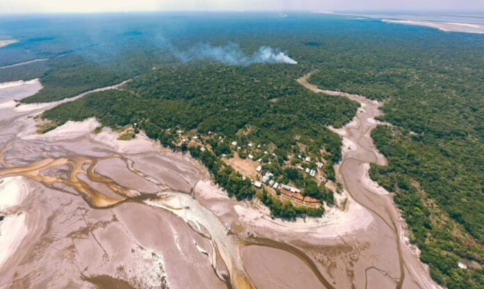 Vista aérea da seca na Amazônia, mostrando rios com margens expostas e impacto nas chuvas da região.