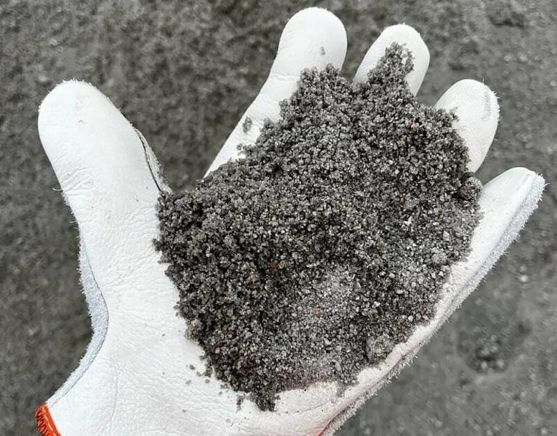 Imagem de luva segurando a Neobrita, a brita reciclada.