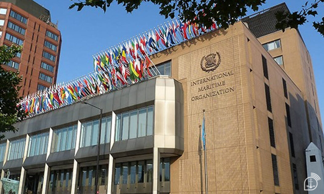 Prédio da IMO com bandeiras de vários países hasteadas, representando o debate internacional sobre redução da descarbonização marítima.