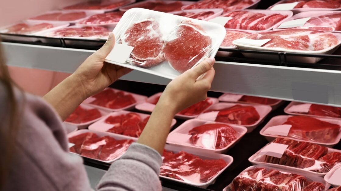 Consumidor seleciona corte de carne em supermercado, tema central da rastreabilidade do Beef on Track.
