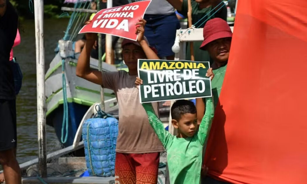 Pescadores seguram faixas em protesto na Ilha de Marajó contra exploração de petróleo na Foz do Amazonas.