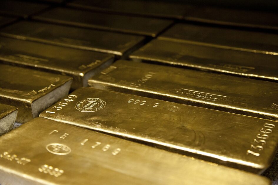 Barras de ouro empilhadas sobre superfície escura, sem identificação de origem. Referência ao ouro ligado ao garimpo ilegal, comprado pela Europa em 2023.