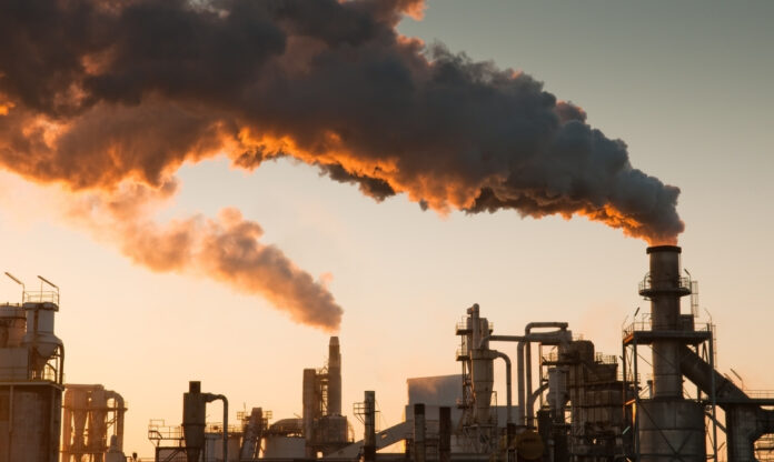 Usina termelétrica emitindo fumaça espessa, símbolo da queima de combustíveis fósseis