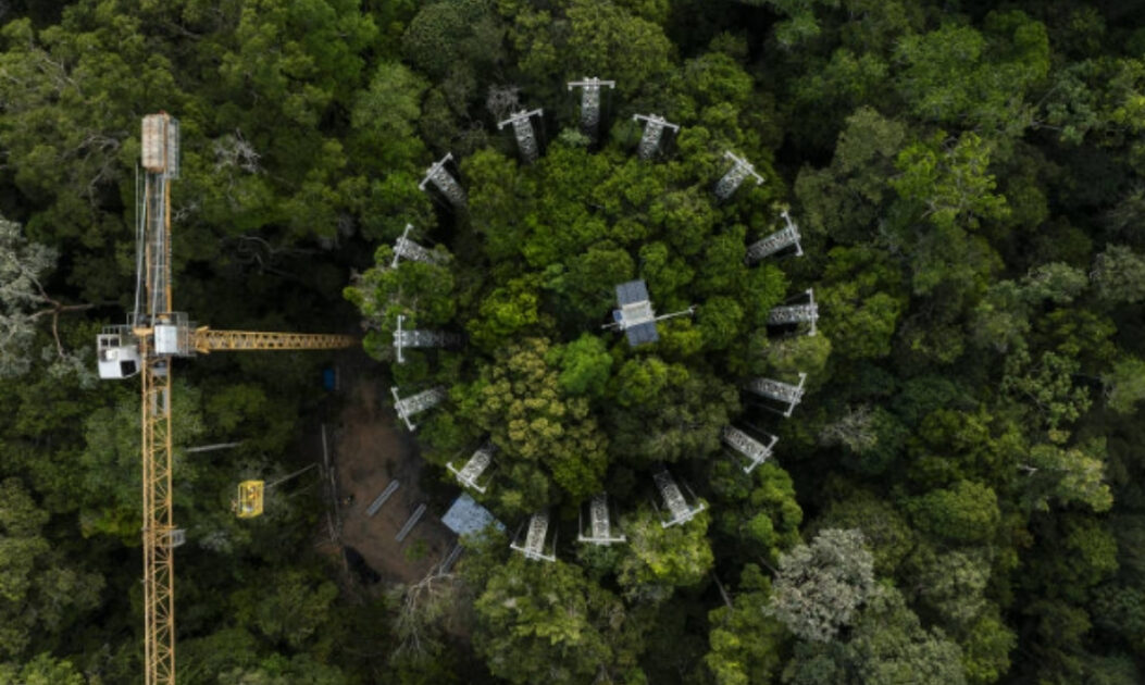 Vista aérea do anel do experimento AmazonFACE, com torres circulares em meio à floresta amazônica.