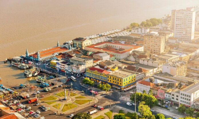 Vista turística de Belém, alvo das críticas do chanceler alemão, com destaque para rio, vegetação e construções históricas.