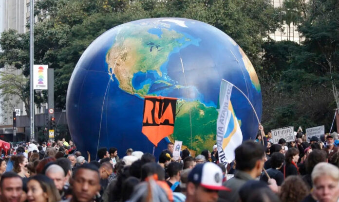 Manifestação com cartazes de apoio à política climática no Brasil.