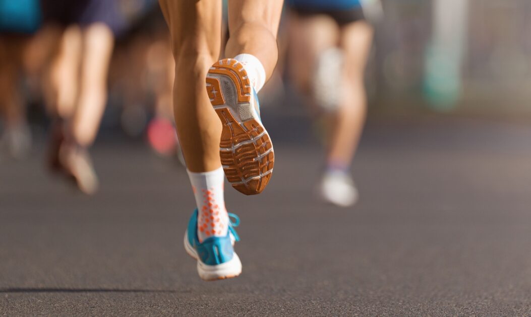 Pé com tênis correndo em ambiente urbano sob efeito da poluição do ar.
