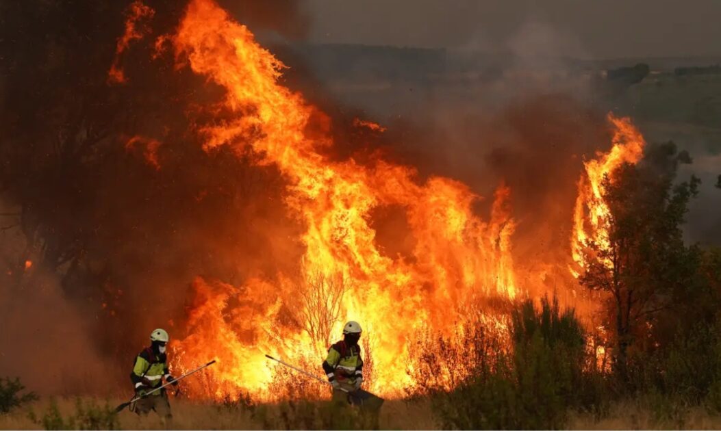 Incêndio florestal de grandes proporções na Europa, com fumaça densa contribuindo para o aumento das emissões de incêndios florestais.