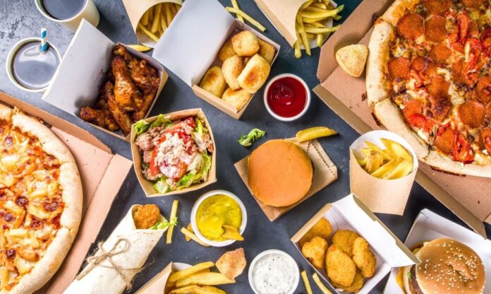 Comidas de fast food como hambúrguer e batata frita servidas em embalagens com substâncias químicas sintéticas.