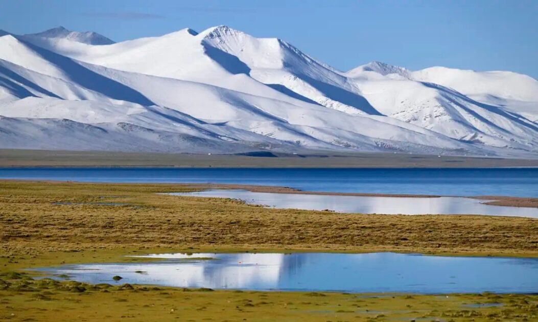 Paisagem do Planalto Tibetano com montanhas e áreas verdes, onde estudos apontam aumento de chuvas associado ao reflorestamento na China.