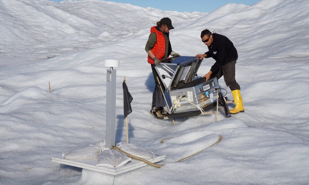 Cientista manuseando sonda científica na Geleira 79°N, na Groenlândia, para monitorar fraturas e fluxo de água.