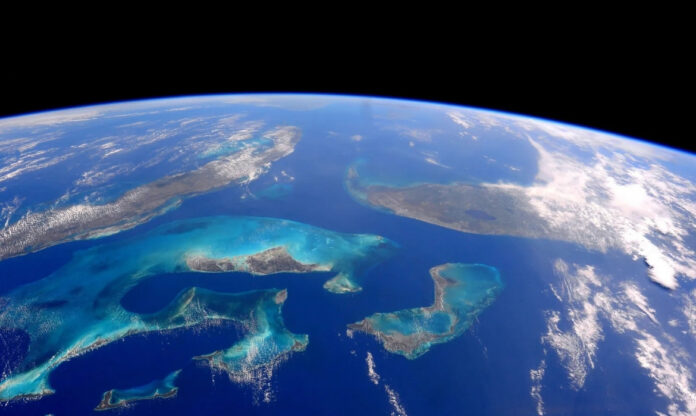 Imagem da Terra vista do espaço mostra os oceanos com tons turquesa no Mar do Caribe e no Oceano Atlântico, na região de Cuba e das Bahamas.