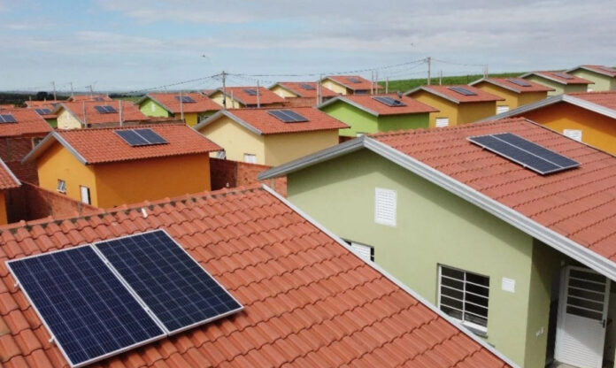 Residências com painéis solares instalados nos telhados em bairro urbano, exemplo da transição energética no Brasil no setor residencial.