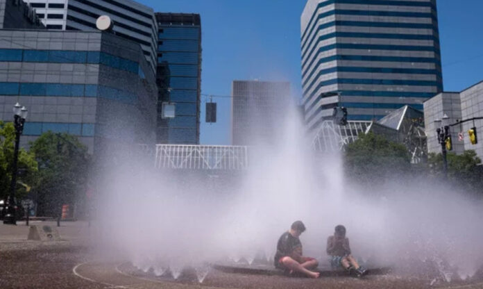 Pessoas em área urbana durante onda de calor nos Estados Unidos, com temperaturas extremas associadas a mortes em Oregon.