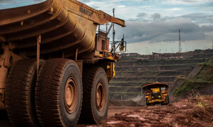 Operação de mineração de ferro da Vale em larga escala, com maquinário industrial e pilhas de minério, ilustrando desafios da mineração sustentável.