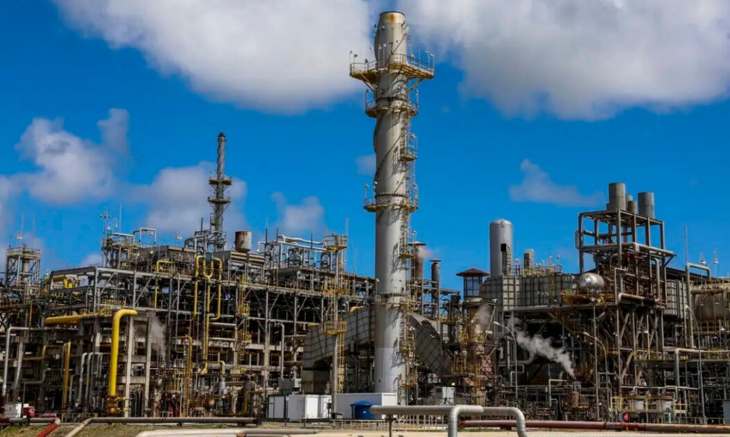 Refinaria de petróleo em operação com emissão de gases, cenário ligado à crise do petróleo e aos combustíveis fósseis