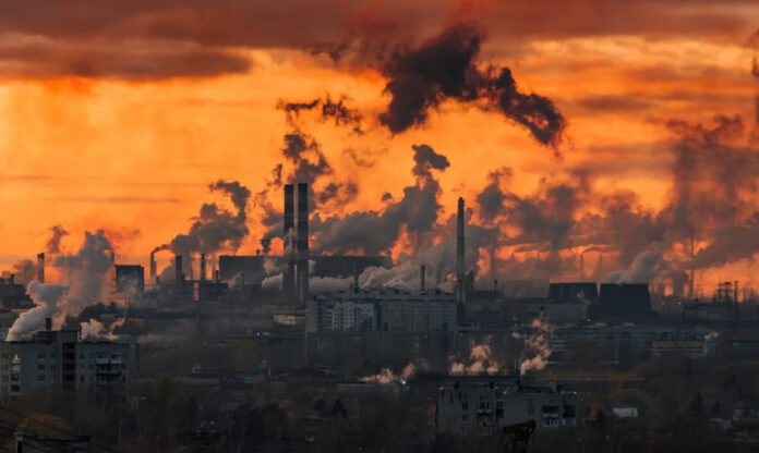 Chaminés industriais liberam fumaça na atmosfera, cenário ligado aos desafios da captura de CO₂.